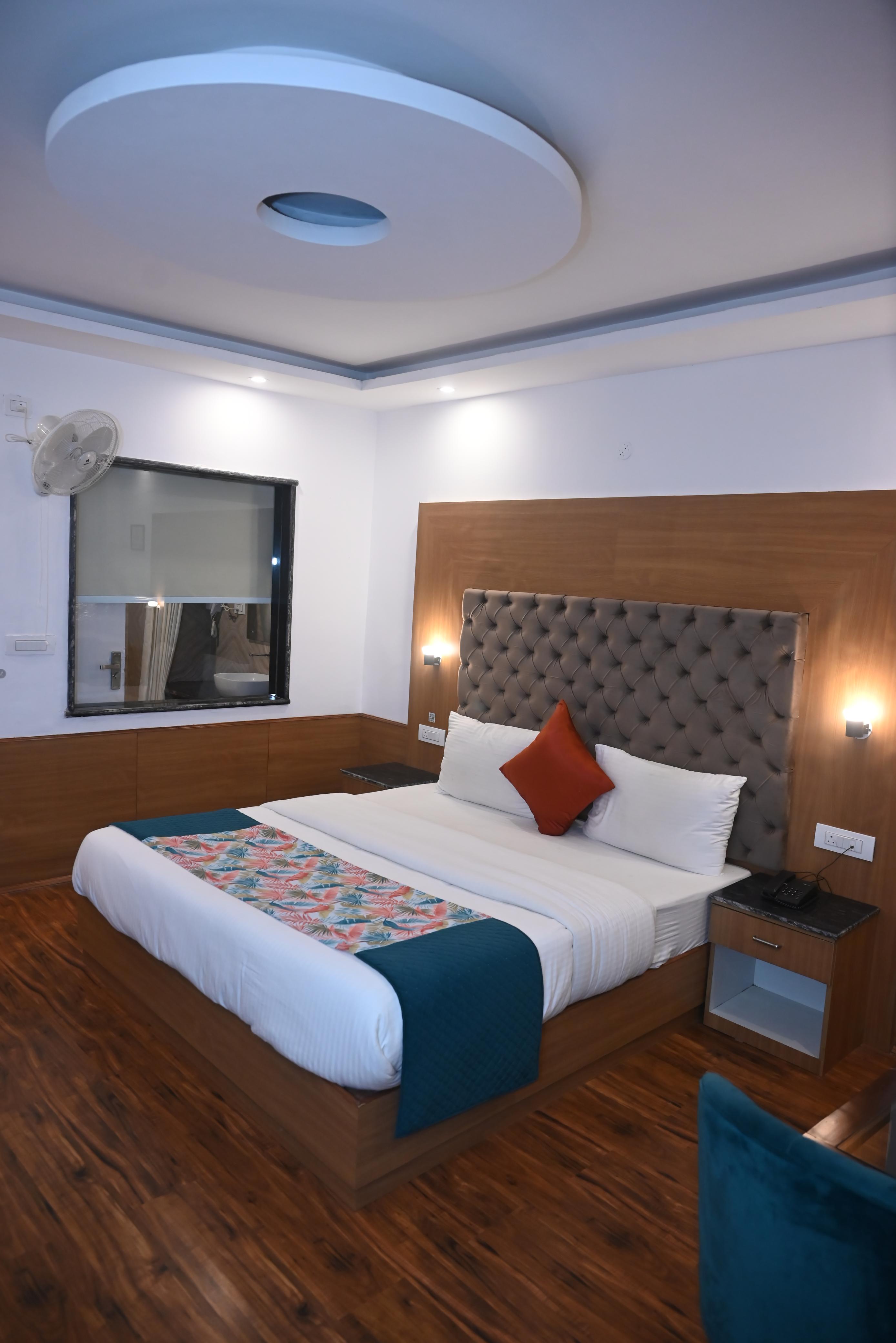 Guest room at the Manali hotel with a king bed and wood-panel interior
