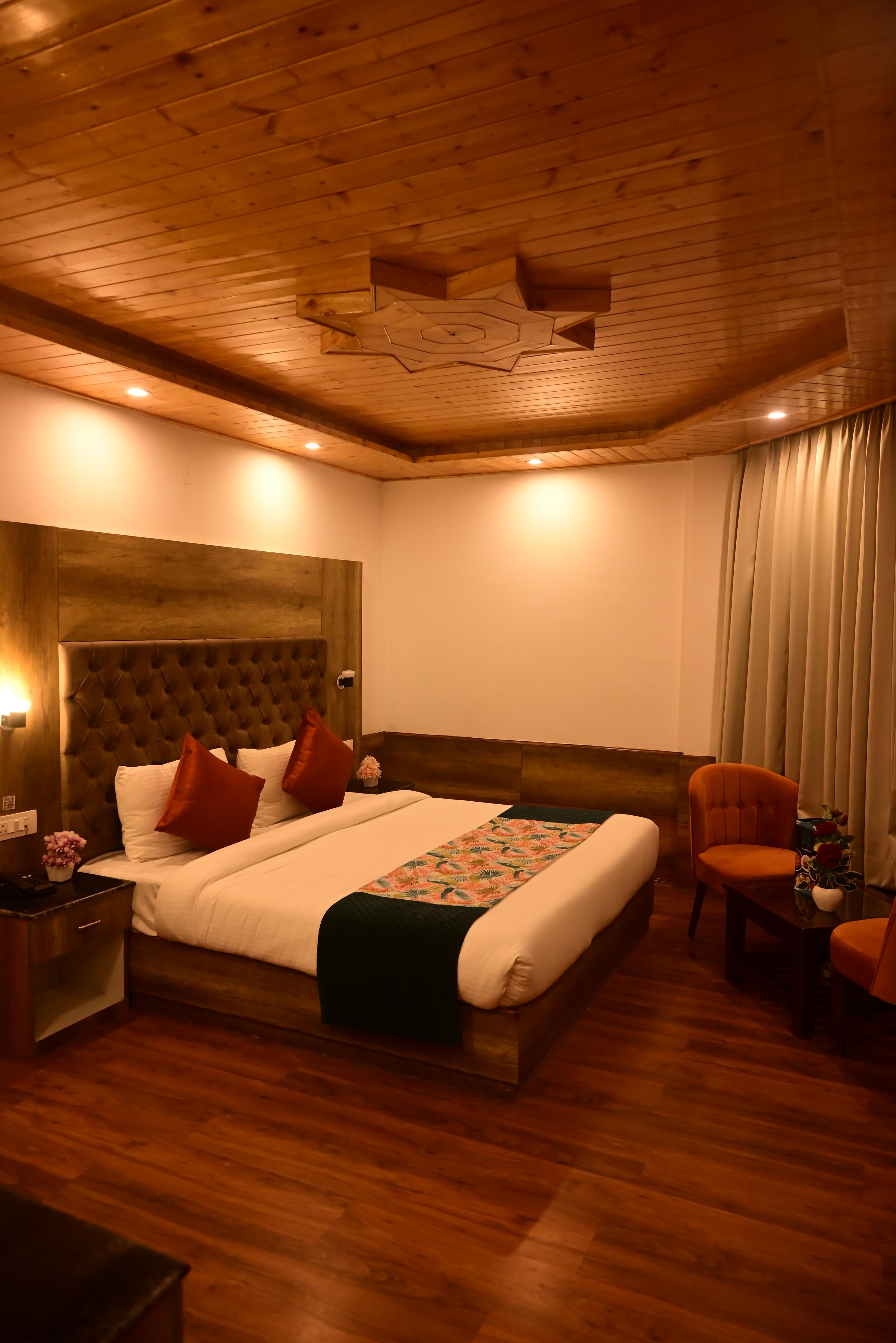 Manali hotel room with wood ceiling and seating